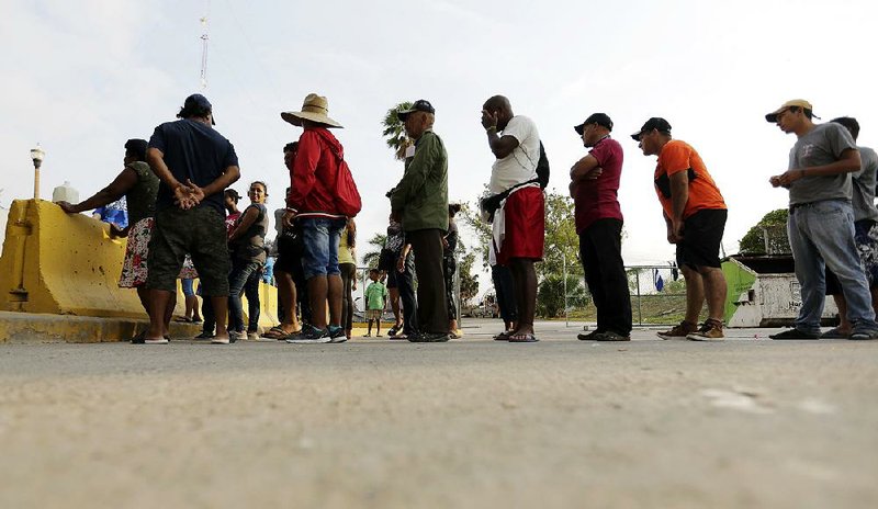 Migrants seeking asylum line up in April for a meal provided by U.S. volunteers in Matamoros, Mexico. One volunteer, Elisa Filippone, described a desperate situation in the gang-ridden city. “I’m afraid that Matamoros is about to catch on fire,” she said. 