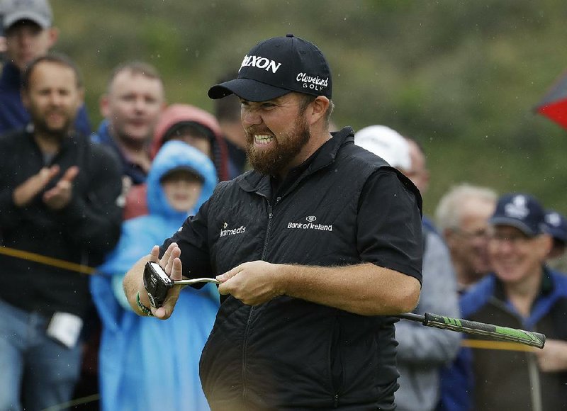 Ireland’s Shane Lowry wipes his putter after he birdied the 10th hole during the second round of the British Open Championship on Friday at Royal Portrush in Northern Ireland. Lowry shot a 4-under 67 and shares the lead with J.B. Holmes, who had a 68.