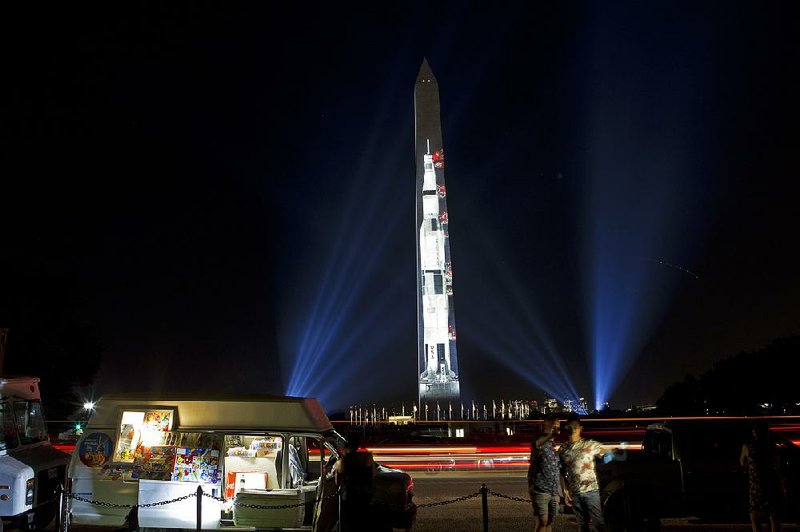 A 363-foot Saturn V rocket used in the Apollo 11 mission is projected to scale on the Washington Monument to illustrate its size as part of festivities for the 50th anniversary of the Apollo moon landing. 