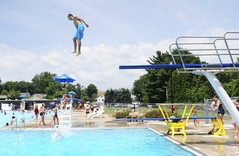 Trevor Klem leaps into the municipal pool Friday in Kingston, Pa., as summer turned up the heat across the country. 