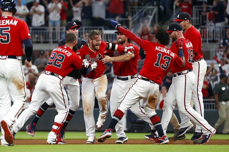 The Associated Press

BRAVE MOB:

Atlanta Braves' Josh Donaldson, center, is mobbed by teammates after driving in the winning run with a base hit in the ninth inning of Friday's game against the Washington Nationals in Atlanta.