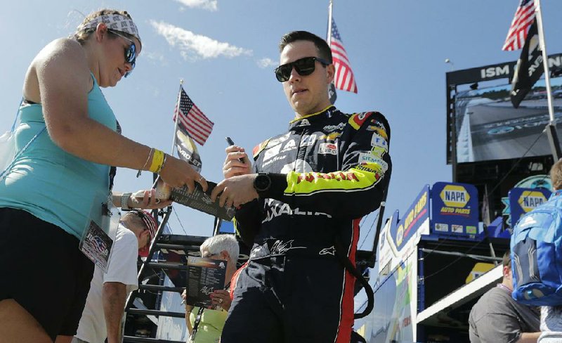 NASCAR Monster Energy Cup driver Alex Bowman signs an autograph for a fan Saturday at New  Hampshire Motor Speedway in Loudon, N.H. After breaking a drive shaft on his qualifying lap  Friday, Bowman crashed his backup car in practice Saturday. He will drive Hendrick Motorsports teammate Jimmie Johnson’s spare car in today’s race. 