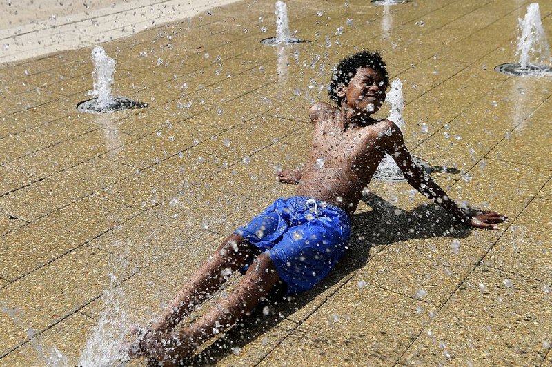 Amari Rogers, 11, of Capitol Heights, Md., finds solace Saturday in a fountain in Washington as temperatures soared into the mid-90s. 