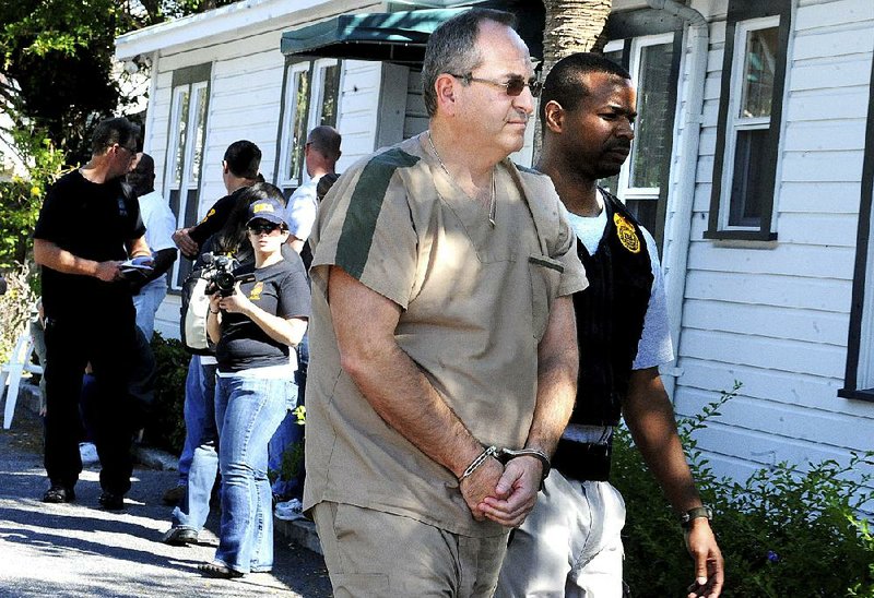 In February 2011, a Drug Enforcement Administration agent escorts Zvi Harry Perper to a police car after his Delray Pain Management clinic was raided by agents in Delray Beach, Fla. 