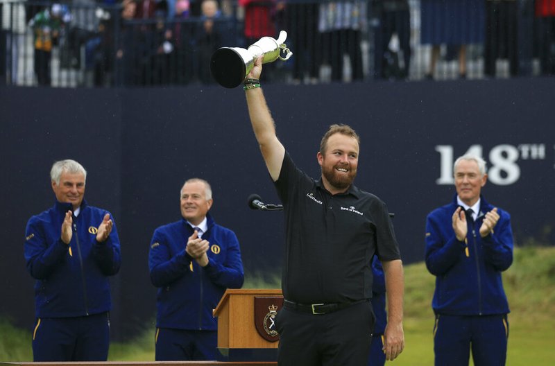 Ireland's Shane Lowry smiles as he holds the Claret Jug trophy aloft after being presented with it for winning the British Open Golf Championships at Royal Portrush in Northern Ireland, Sunday, July 21, 2019.(AP Photo/Jon Super)