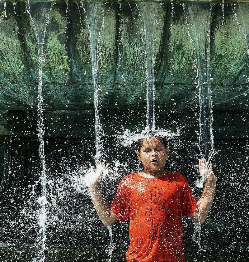 Alex Paladino cools off Sunday in the Eakins Oval fountain in Philadelphia as the city, and much of the eastern U.S., faces another day of stifling heat. 