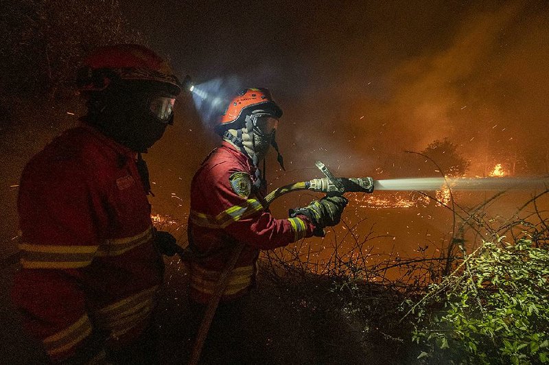 Firefighters work Sunday to extinguish a wildfire near Cardigos in central Portugal. 
