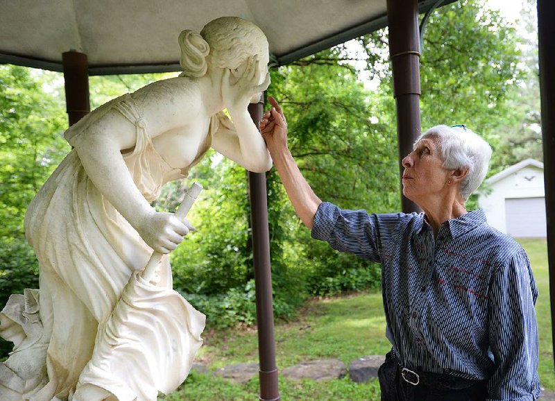 Joyce Hale tends to the sculpture Nydia, The Blind Flower Girl of Pompeii by Randolph Rogers in the backyard of her Fayetteville home. 