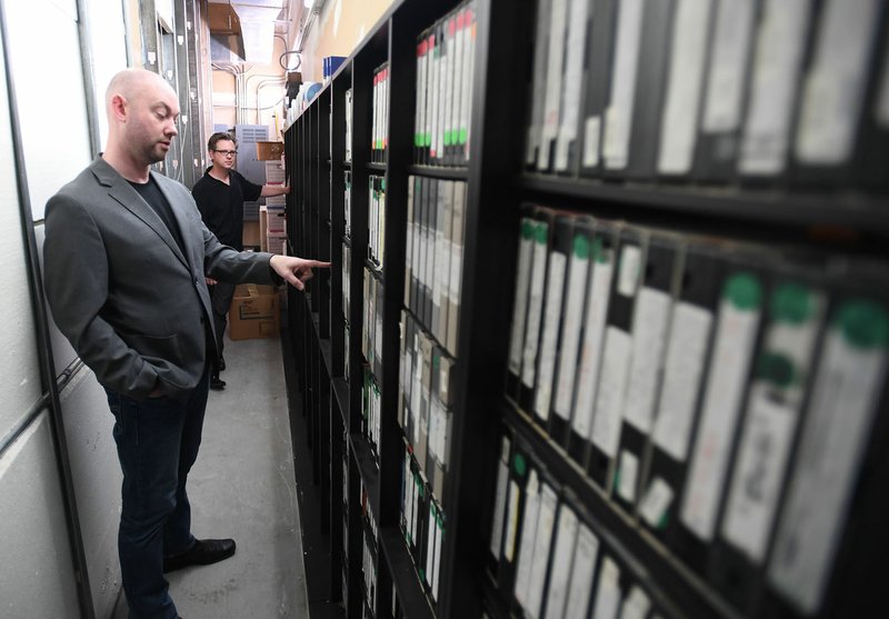 NWA Democrat-Gazette/J.T. WAMPLER Dan Robinson, operational manager for Fayetteville Public Television, points out tapes Thursday at the station's archive room. The public access station has about 2,000 tapes and is looking for volunteers to help with a project to digitize its archives.