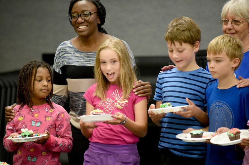 NWA Democrat-Gazette/DAVID GOTTSCHALK Mara Masterson (second from left), 9, reacts Wednesday during the announcement of her winning cupcake during the Cupcake War contest at the Next Great Baker Camp at Prism Education Center in Fayetteville. The private, nondenominational religious school is asking the Fayetteville Planning Commission to expand its campus east onto adjacent land.