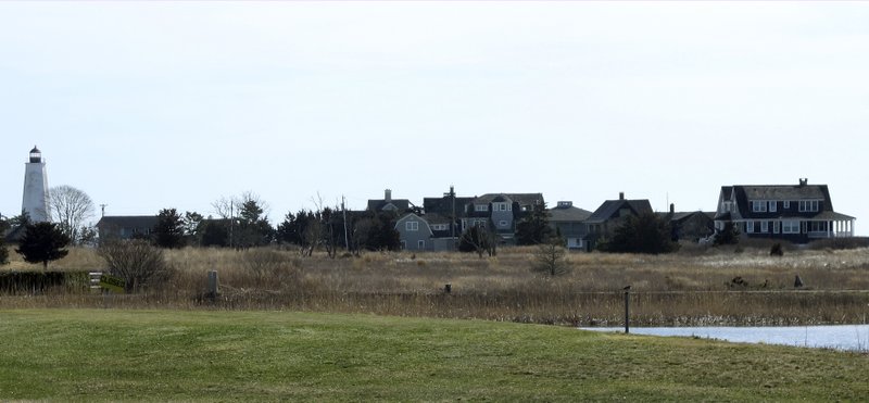 In this April 2, 2019 photo, multimillion-dollar homes and a lighthouse sit on a peninsula in Old Saybrook, Conn. The homes are among more than 900 structures on the East Coast that would become newly eligible for federal disaster aid, under a proposed remapping of coastal protection zones by the U.S. Fish &amp; Wildlife Service. (AP Photo/Dave Collins)
