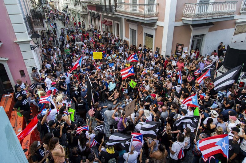 Demonstrators protest against Gov. Ricardo Rossello in San Juan, Puerto Rico, Sunday, July 21, 2019. Puerto Rico's embattled governor says he will not seek re-election but will not resign as the island's leader, though he will step down as head of his pro-statehood party. (AP Photo/Dennis M. Rivera Pichardo)

