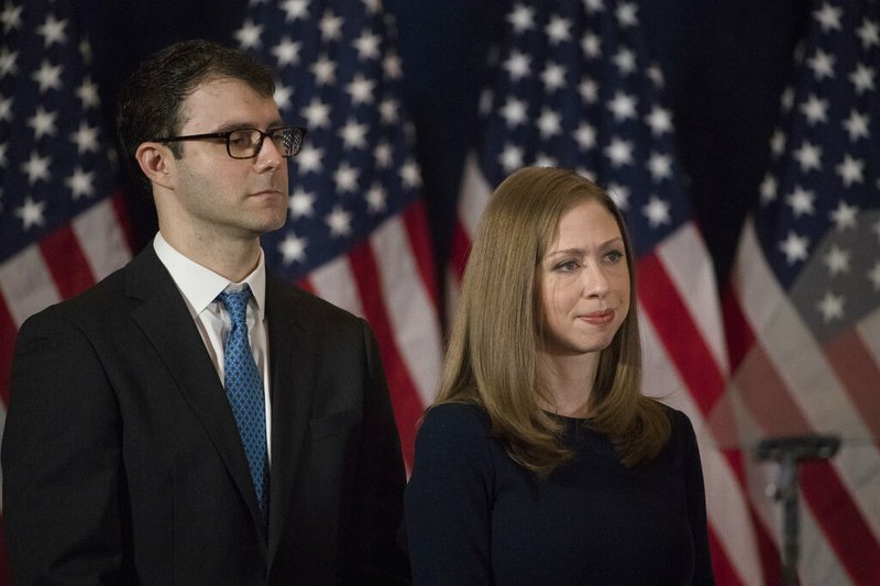 FILE - In this Nov. 9, 2016 file photo Chelsea Clinton and her husband Marc Mezvinsky listen to her mother Democratic presidential candidate Hillary Clinton speak in New York. Clinton has announced the birth of her third child. Jasper Clinton Mezvinsky was born on Monday, July 22, 2019. Clinton announced the birth on Twitter, saying they "are overflowing with love and gratitude and can’t wait to introduce him to his big sister and brother." (AP Photo/Matt Rourke, file)