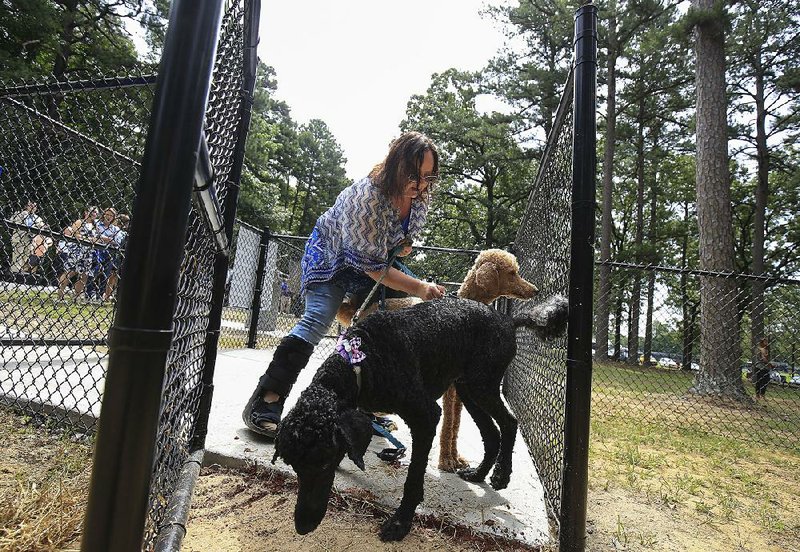 Candace Barron unleashes her poodles, Remington (front) and Demi, on Monday as she enters the new dog park at North Little Rock’s Burns Park. More photos are available at arkansasonline.com/723dogpark/ 