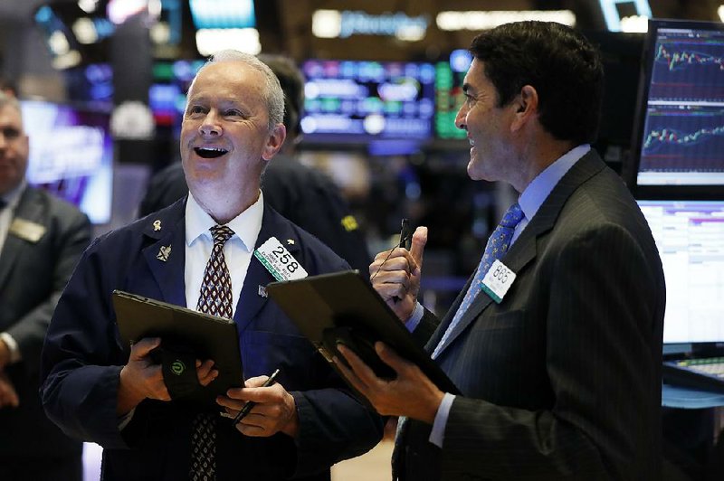 Traders James Riley (left) and Mark Muller work Monday on the floor of the New York Stock Ex-change. 