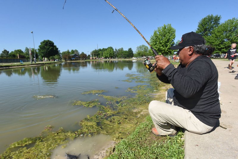Felix Soto reels in a channel catfish May 26 2018 at Veteran's Park in Rogers during the Care Community Center family fishing derby. Worms or nightcrawlers are excellent bait for channel catfish. Flathead catfish prefer sunfish or large minnows.