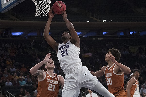 TCU center Kevin Samuel (21) goes to the basket past Texas forward Dylan Osetkowski (21) and forward Jericho Sims (20) during the first half of a semifinal college basketball game in the National Invitational Tournament, Tuesday, April 2, 2019, at Madison Square Garden in New York. (AP Photo/Mary Altaffer)
TCU center Kevin Samuel (21) goes to the basket past Texas forward Dylan Osetkowski (21) and forward Jericho Sims (20) during the first half of a semifinal college basketball game in the National Invitational Tournament, Tuesday, April 2, 2019, at Madison Square Garden in New York. (AP Photo/Mary Altaffer)