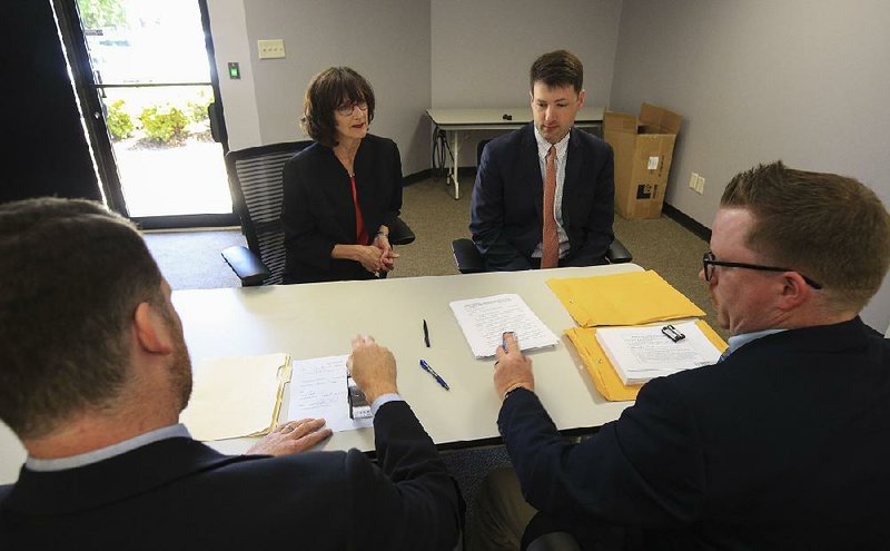 In this file photo Dr. Laurie Barber, chairman for the Safe Surgery Committee, and attorney Alex Gray turn in petitions to Brandon Newell (left), assistant director of elections, and Josh Bridges (right), election coordinator, at the secretary of state’s office. 
