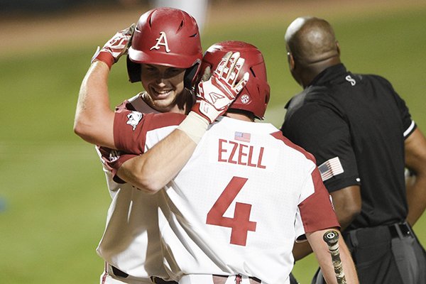Arkansas designated hitter Matt Goodheart (10) hugs Trevor Ezell (4) after a score during an NCAA regional game against TCU on Sunday, June 2, 2019, in Fayetteville.