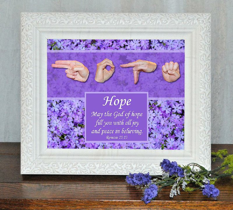 A framed work by Connie Rowland, “God of Hope,” is one of dozens of pieces of faith-inspired art the Bentonville resident has created. Although her art depicts American Sign Language finger spellings, Rowland says her work is intended for everyone. 