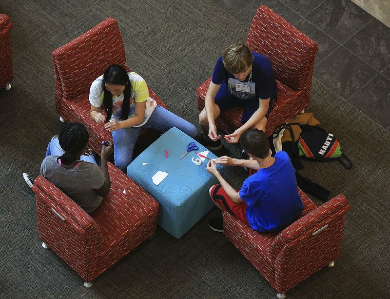 Working in pairs, high school students (clockwise from left) Nekyehia McDonald, 15; Maya Henderson, 16; Jude Burgess, 16; and Samuel O’Connor build rockets out of straws Thursday during the Arkansas Advanced Initiative for Math and Science Advanced Placement work- shop held at the University of Arkansas at Little Rock. More photos are available at arkansasonline.com/726APworkshop/. 