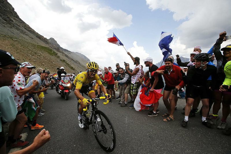 France’s Julian Alaphilippe, the overall leader of the Tour de France, climbs the Galiber pass during Wednesday’s 18th stage as cheering fans crowd the roadway. Alaphilippe made daring run over the 11-mile descent after the climb to maintain his lead. 
