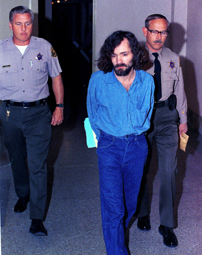 Charles Manson is escorted by deputy sheriffs on his way to court in 1970 after being charged with murder and conspiracy in the Tate-LaBianca killings. (AP)