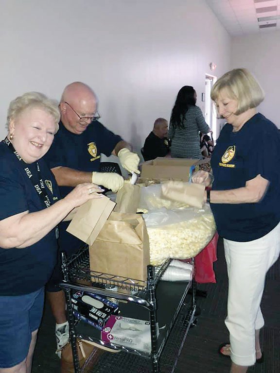 Jacksonville Citizen Police Academy members Donna Harts, left, and her husband, Howard, along with Pat Colford, bag popcorn for the first Family Movie Night on July 19 in the Jacksonville Police Department’s FEMA Room. The second Family Movie Night, sponsored by the Jacksonville Police Department and the Boys & Girls Club of Jacksonville, will take place Friday. The movie Max will be shown at 6 p.m. The doors will open at 5:30.