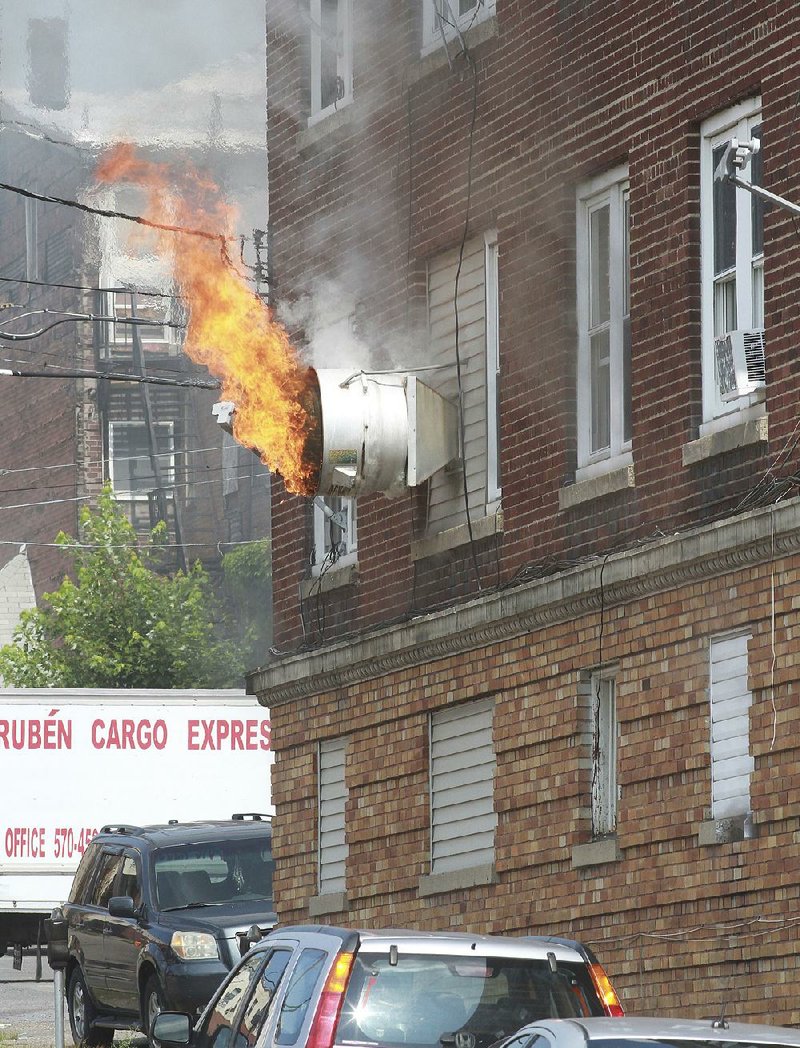 Flames shoot out of a kitchen vent Friday at Prestigio restaurant in Hazleton, Pa. Firefighters used an aerial truck to rescue people, including two babies, from the third floor of the building. 