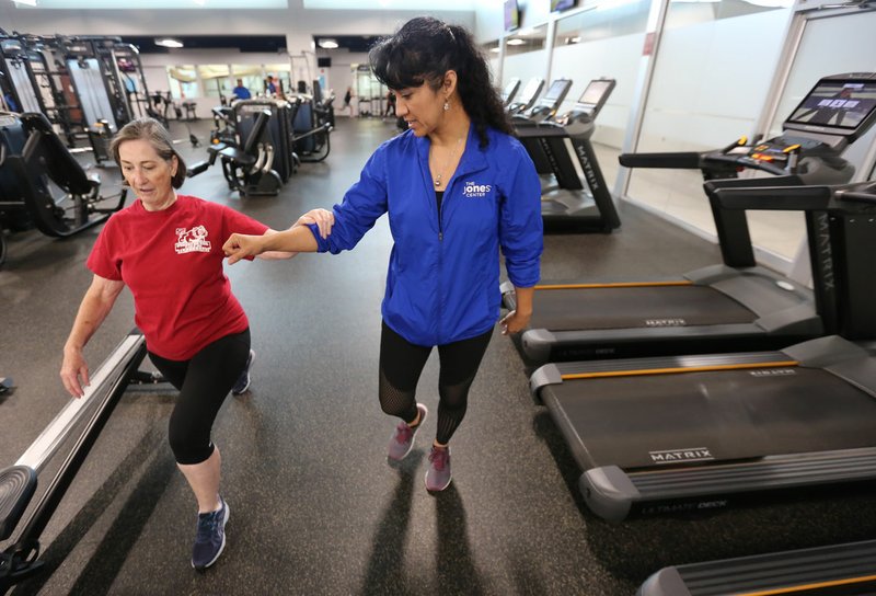 NWA Democrat-Gazette/DAVID GOTTSCHALK Luisa Espinoza (right), a personal trainer, guides Kathryn Birkhead through a set of lunges July 8 at the Jones Center in Springdale. Espinoza immigrated from Mexico and teaches her classes in both English and Spanish.