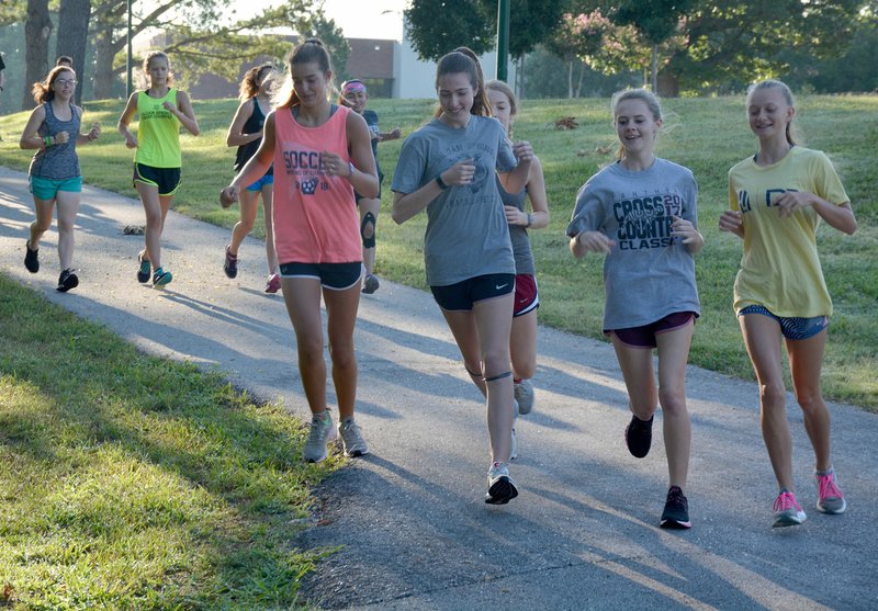 Graham Thomas/Siloam Sunday Members of the Siloam Springs cross country team run along the bike trails on the campus of John Brown University during cross country practice on Wednesday morning.