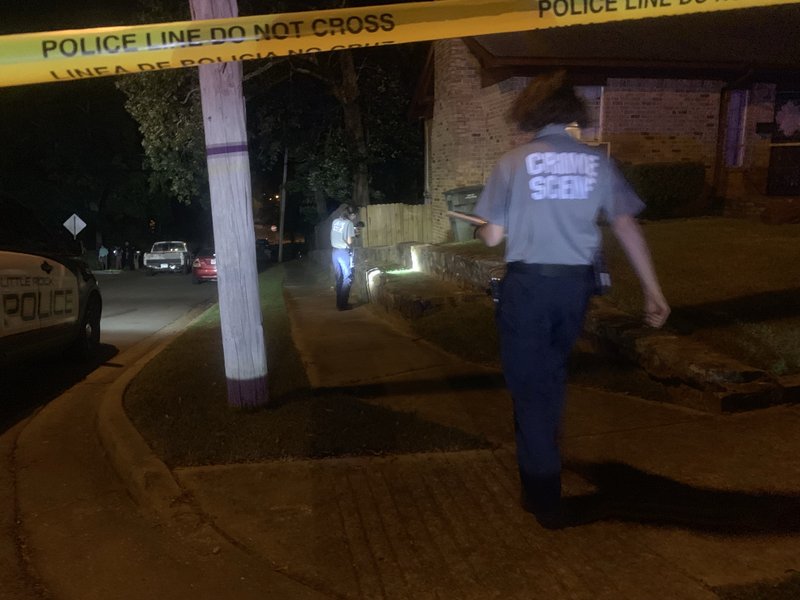 Crime scene investigators examine the site of a shooting that killed one man and injured another in Little Rock on Saturday night.  