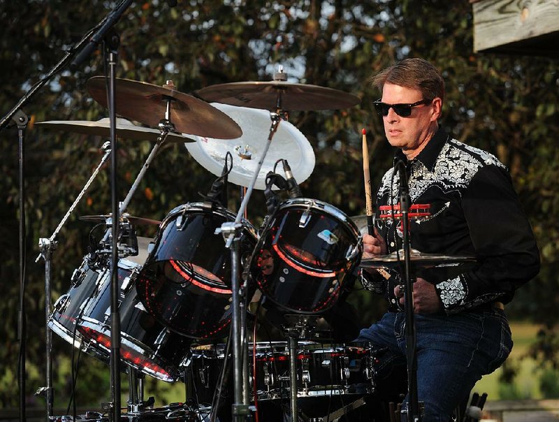 Scott Varady, executive director of the Razorback Foundation, plays drums Thursday with his band Mary-Heather Hickman and The Sinners during the 23rd annual Gulley Park Summer Concert Series in Gulley Park in Fayetteville.