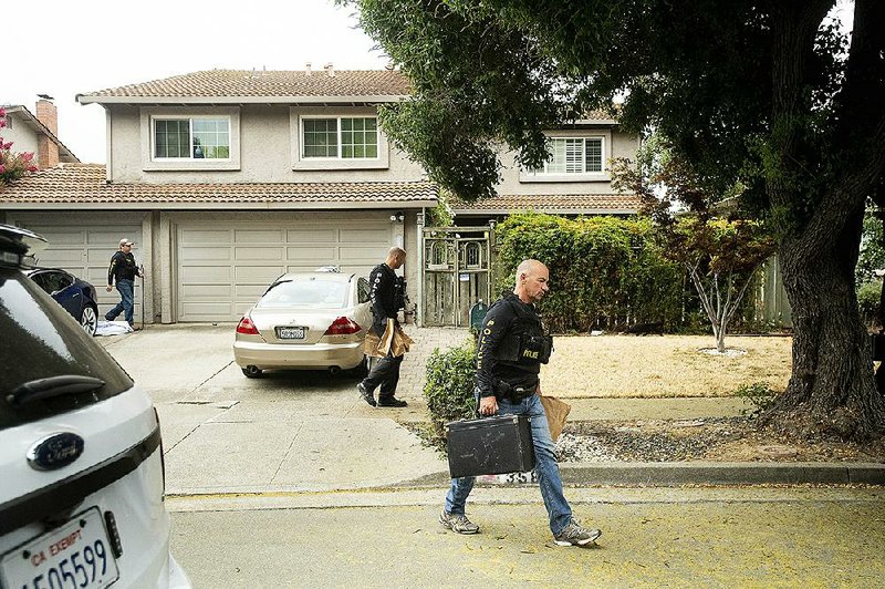 Police officers on Monday remove bags of evidence from the family home of Santino William Legan, the gunman in Sunday’s attack in Gilroy, Calif.