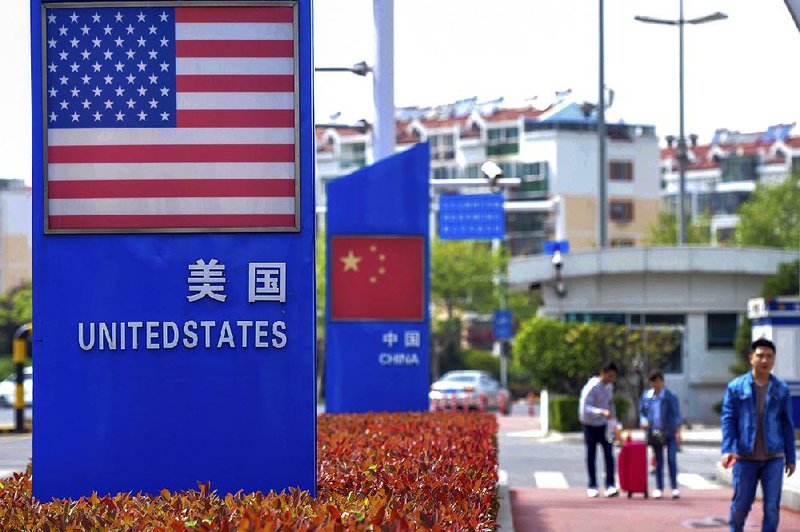 A display featuring the U.S. and Chinese flags is shown in a special trade zone in Qingdao, China. 