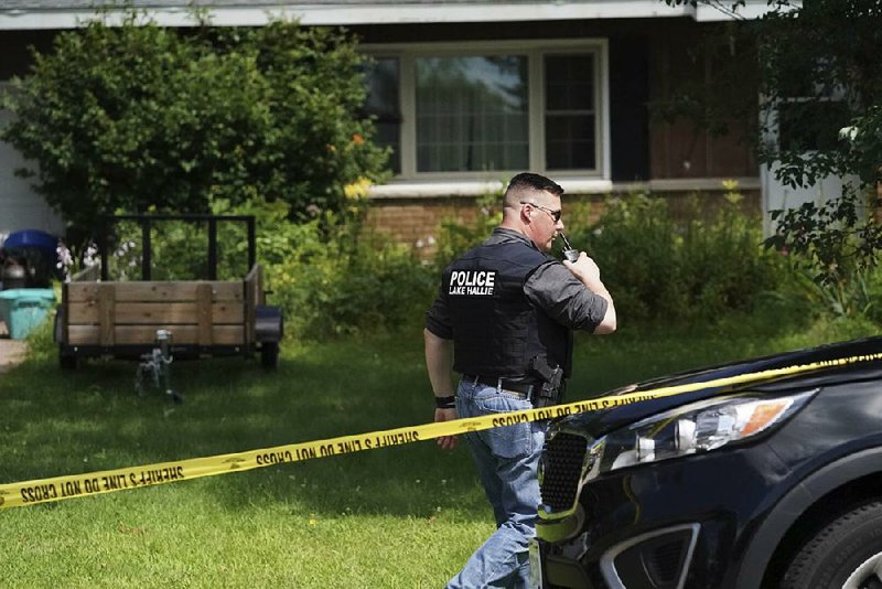 A Lake Hallie, Wis., police officer works outside a home Monday after the fatal shootings.