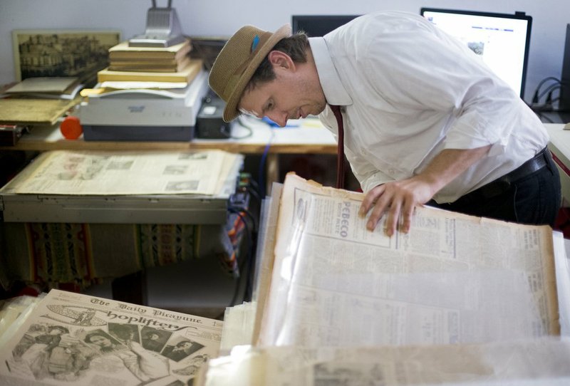 Joseph Makkos, a vintage newspapers collector, looks through a collection of newspapers in New Orleans in a May 23 photo. Makkos acquired roughly 30,000 New Orleans newspapers dating from 1885 to the 1930s from Craigslist in 2013. (Photo by Brett Duke/The Times-Picayune via AP)