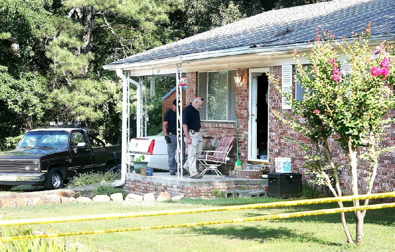 Hot Springs police Sgt. Jerry Freeman (right) works Tuesday at the scene of fatal shooting at 101 Carla Circle in Hot Springs. Officers said Christopher Brock, 24, was killed inside the house in a case of “domestic violence.” 