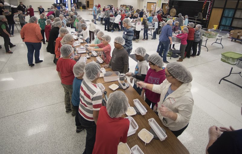 NWA Democrat-Gazette/J.T. WAMPLER Elm Tree Elementary fourth graders pack meals with the Pack Shack Tuesday Dec. 20, 2016.