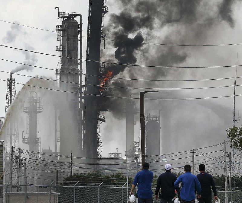 Flames and smoke pour out of an Exxon Mobil oil refinery Wednesday in Baytown, Texas, after an explosion that left 37 people with minor injuries. It was the latest in a series of petrochemical blazes in the Houston area. 