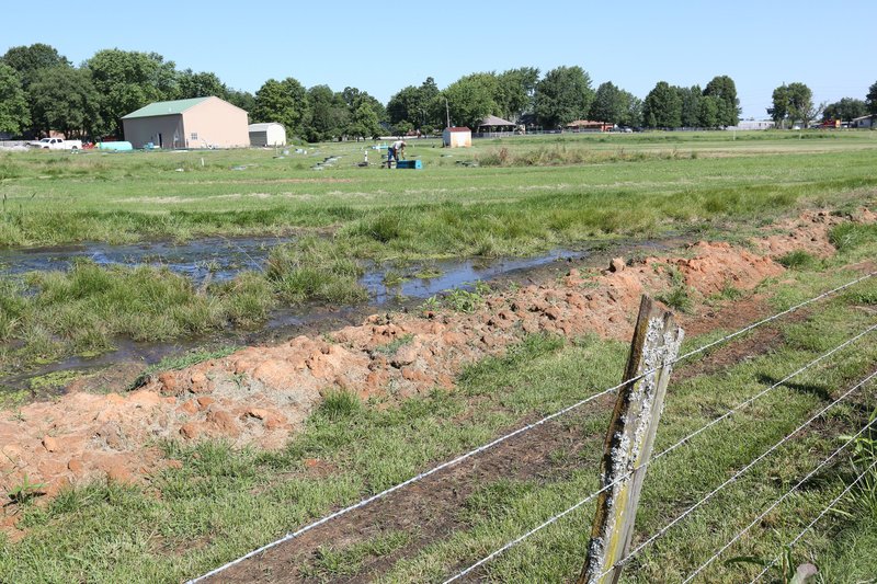 File Photo/NWA Democrat-Gazette/DAVID GOTTSCHALK Standing surface water is visible June 13 on the property of Bethel Heights' Lincoln Street Waste Water Treatment Plant.