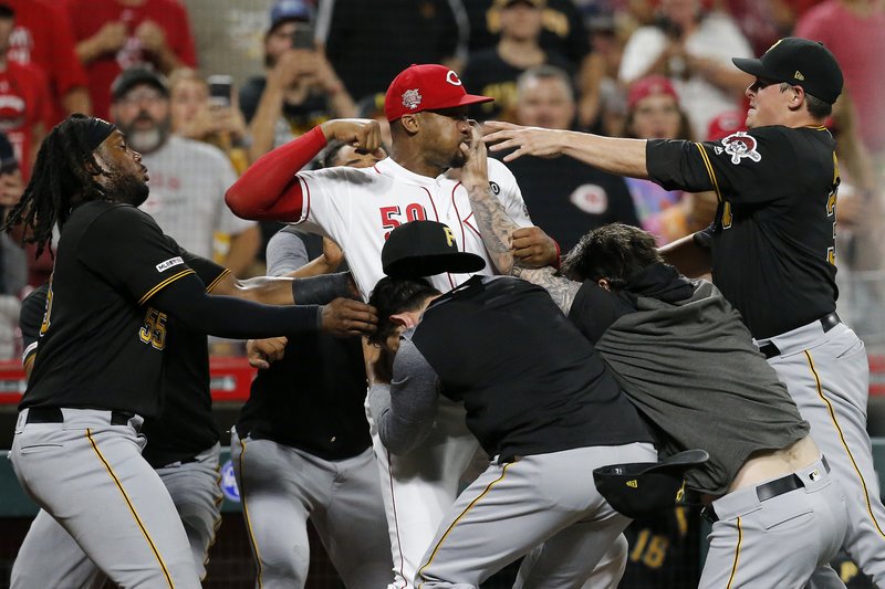 Cincinnati Reds relief pitcher Amir Garrett (50) looks to throw a punch as he is held back by a number of Pittsburgh Pirates players during a brawl in the ninth inning of a baseball game in Cincinnati on Tuesday, July 30, 2019. The Pirates won 11-4. (Sam Greene/The Cincinnati Enquirer via AP)