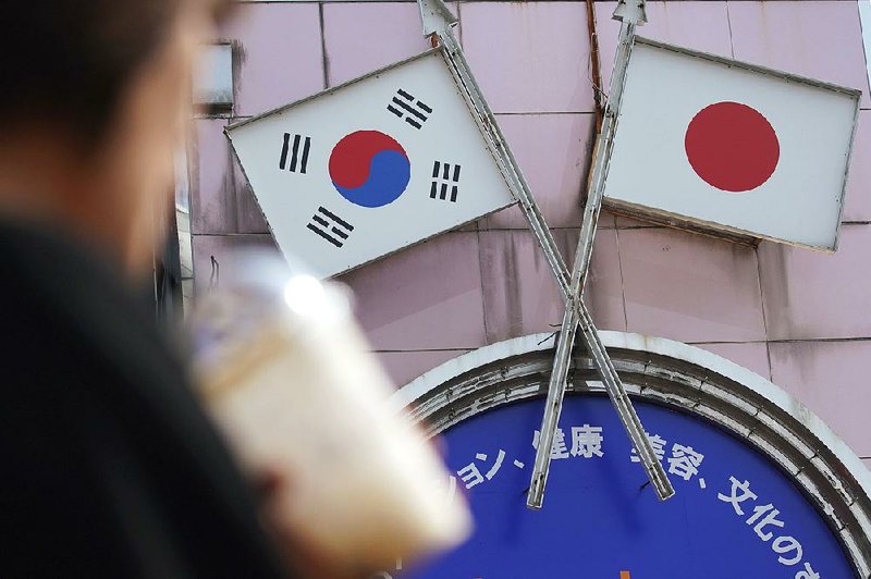 An advertisement features Japanese and South Korean flags at a shop Friday in Tokyo. A Japan Cabinet vote on South Korea’s trade status has strained relations between the two countries. 