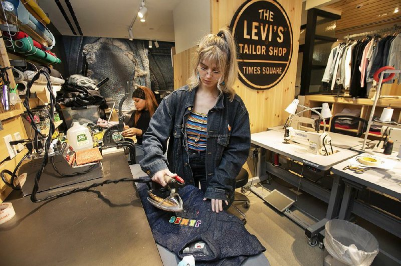 Tailors Latoya Henderson (left) and Aly Reinert work in June in the Levi’s Tailor Shop in the Levi’s store in New York’s Times Square, a flagship store which has been reconfigured from its original retail
venue. 