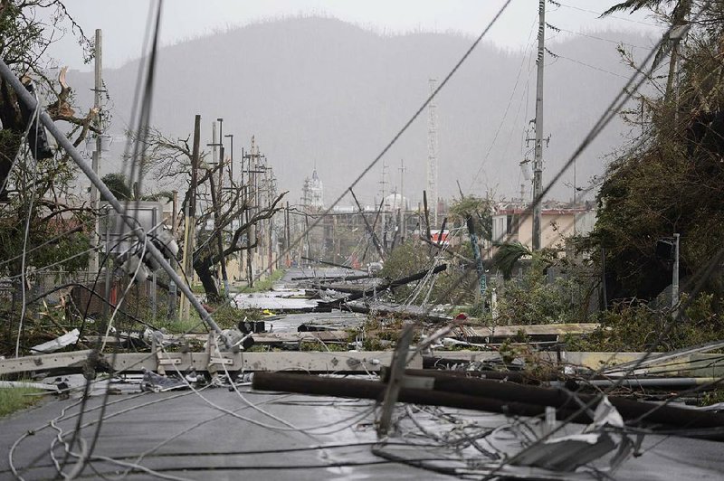 In this photo taken in September of 2017, electricity poles and lines lay toppled on the road after Hurricane Maria hit the eastern region of the island, in Humacao, Puerto Rico. 