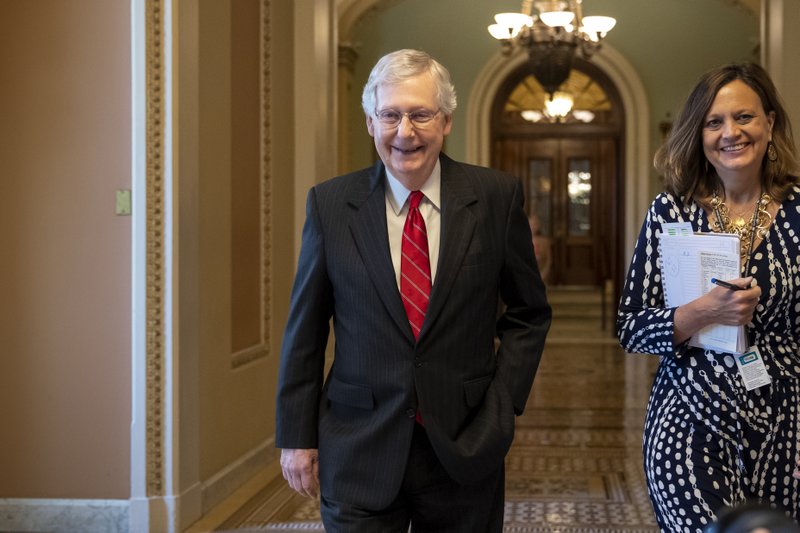 Senate Majority Leader Mitch McConnell, R-Ky., accompanied by Sharon Soderstrom, his chief of staff, smiles after a vote on a hard-won budget deal that would permit the government to resume borrowing to pay all of its obligations and would remove the prospect of a government shutdown in October, at the Capitol in Washington, Thursday, Aug. 1, 2019. (AP Photo/J. Scott Applewhite)