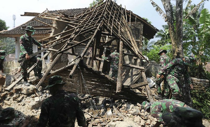 Soldiers remove debris Saturday from a house that was damaged by an earthquake in Pandeglang, Indonesia. 