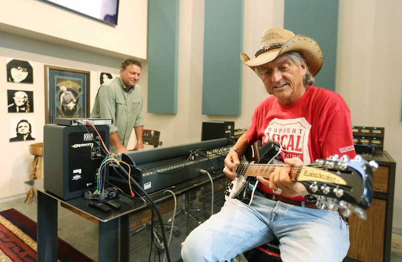 Ben Meade (right), owner of Cosmic Cowboy Studio and Cosmic Cowboy Records, listens Friday to the sound of a 12-string Rickenbacker guitar with Ted Runnels, producer, in the studio in Fayetteville. The record company anticipates producing 13 albums by April 2020, Meade said. The studio stands out, Meade said, because it’s the only one in the region recording music using solely analog equipment. 