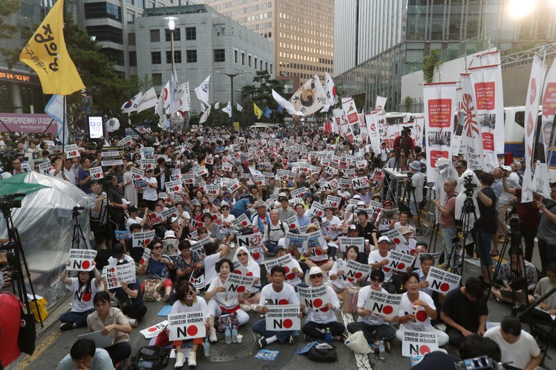 South Korean protesters stage a rally to denounce Japan's new trade restrictions on South Korea in front of the Japanese embassy in Seoul, South Korea, Saturday, Aug. 3, 2019. Japan's Cabinet on Friday approved the removal of South Korea from a list of countries with preferential trade status, prompting retaliation from Seoul where a senior official summoned the Japanese ambassador and told him that South Koreans may no longer consider Japan a friendly nation.  (AP Photo/Ahn Young-joon)
