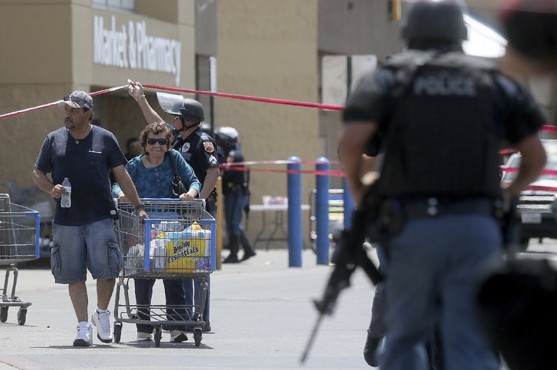 Walmart customers are escorted from the store after a gunman opened fire on shoppers near the Cielo Vista Mall, Saturday, Aug. 3, 2019, in El Paso, Texas. Multiple people were killed and one person was in custody after a shooter went on a rampage at the shopping mall, police in the Texas border town of El Paso said. (Mark Lambie/The El Paso Times via AP)